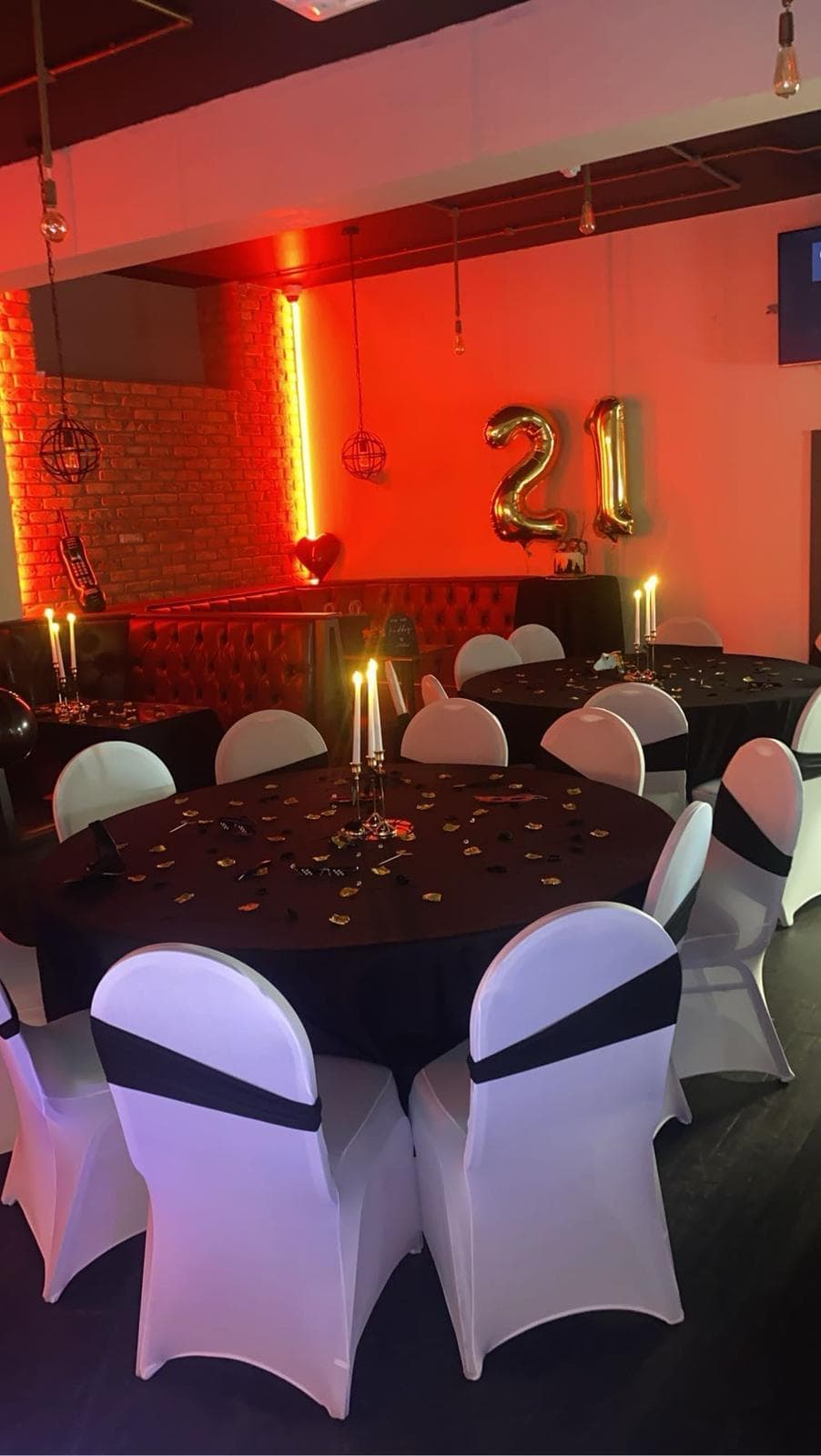 Candlelit round tables in a red glow